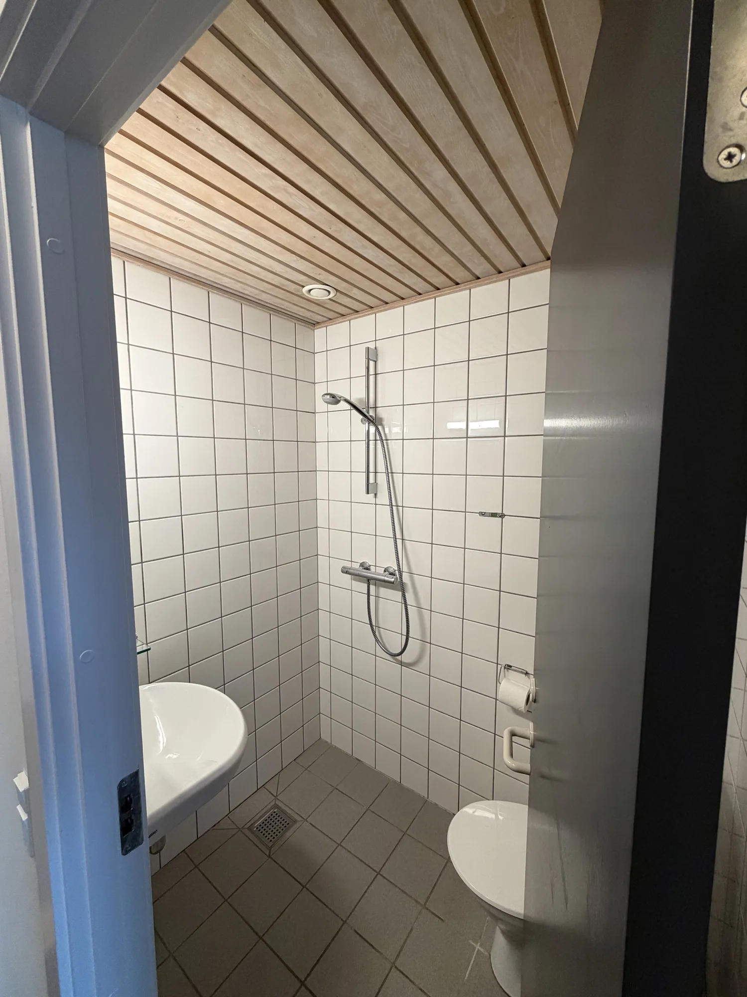 Badeværelse på Motel Storstrøm med hvidt fliseværk og bruseniche