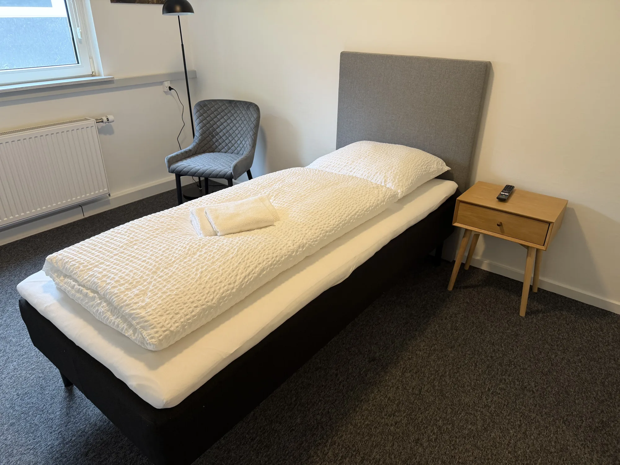 Enkeltværelse på Motel Storstrøm med seng, skrivebord og plante