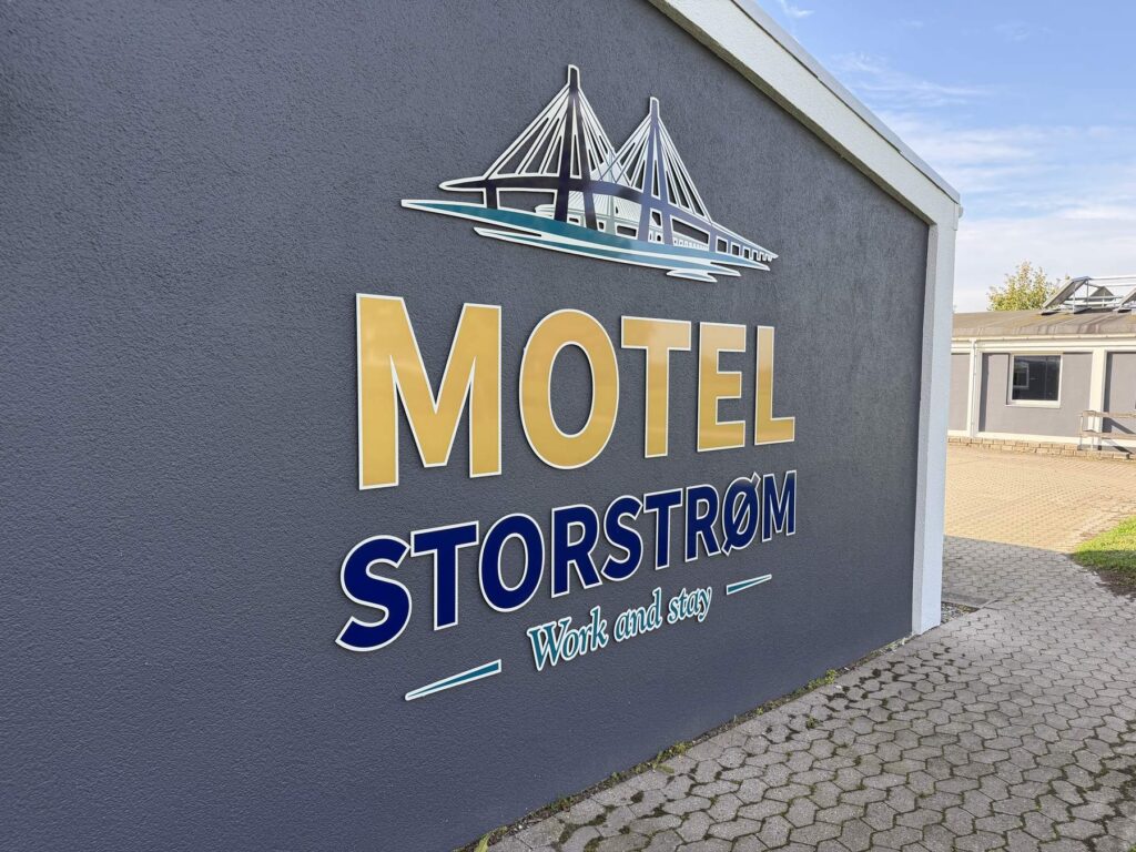 Motel Storstrøm logo med bro og teksten Work and stay på mørkeblå gavl